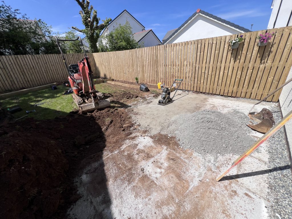 a construction site with a pile of dirt and a fence